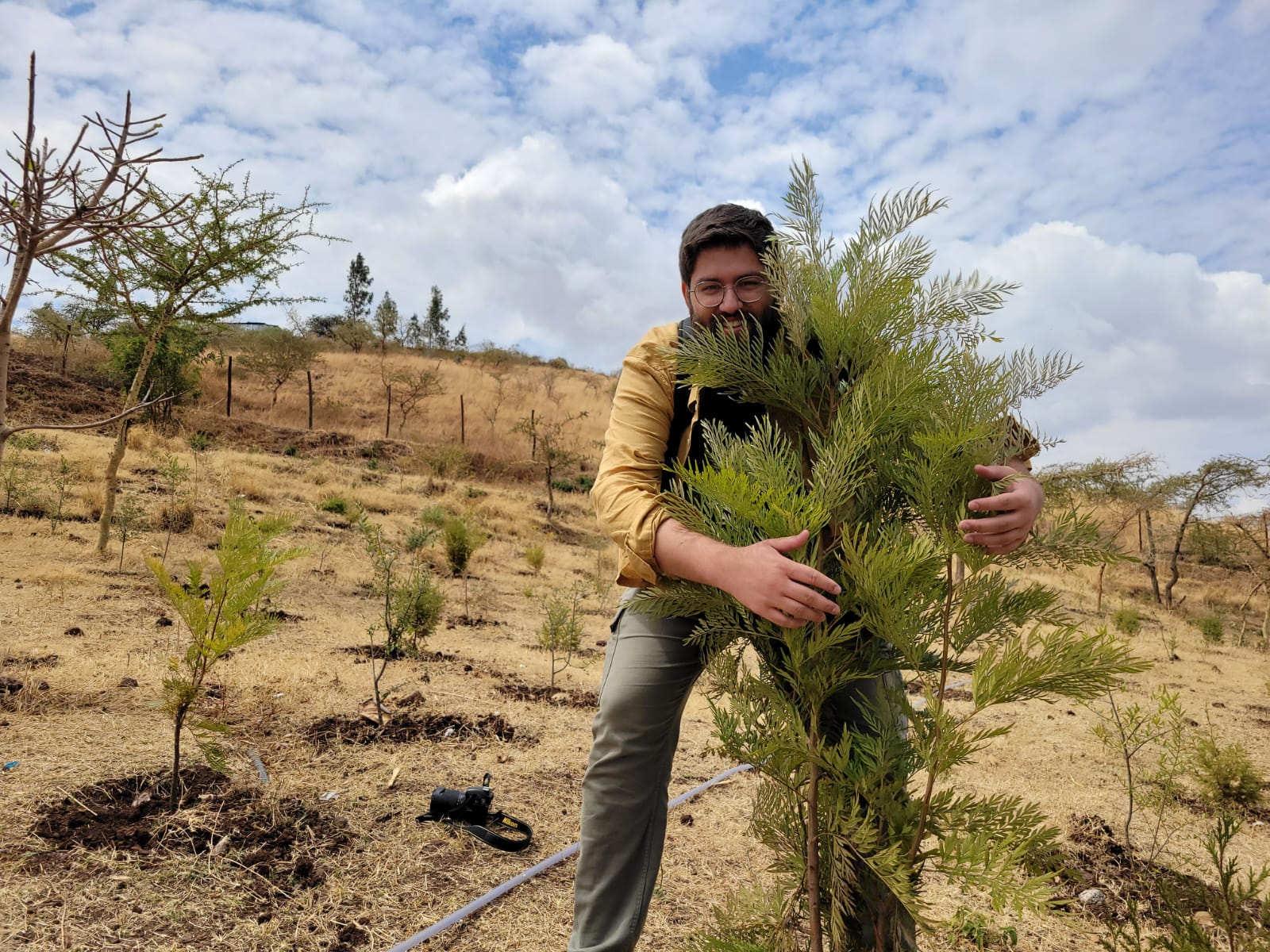 Dominik hiding behind a young tree.